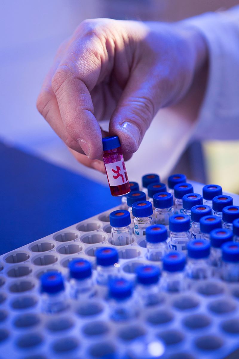 Hand picking up a small test tube